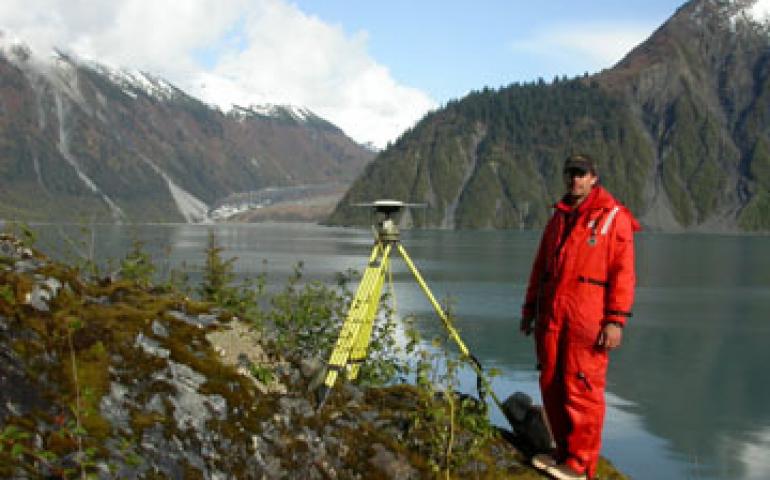  Geophysical Institute research assistant Adam Bucki stands next to a GPS antenna at one of 76 spots in Southeast Alaska. Scientists are using the sites, such as this one in Lituya Bay, to find that Southeast is one of the fastest-rising areas on Earth. Ned Rozell photo. 