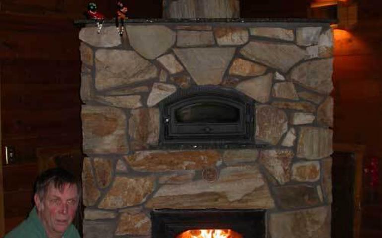  Bill Reynolds of Fairbanks next to his masonry heater. Photo by Ned Rozell. 