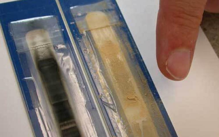  Atmospheric scientist Cathy Cahill points to two recent air samples from Baghdad, one showing dust and the other fine trapped particles from burned diesel fuel. Photo by Ned Rozell. 