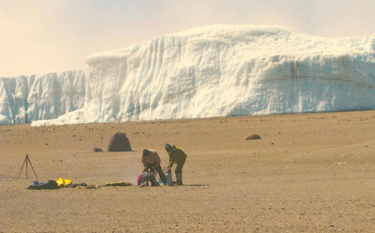  Kenji Yoshikawa, Kenji Narita, and guide Romli Otto who helped with a climb up Mount Kilimanjaro drill a permafrost monitoring hole near the volcano’s summit. In the background is Furtwängler Glacier, a remnant of a large icecap that used to cover Kilimanjaro’s summit. Photo by Mike O’Toole. 