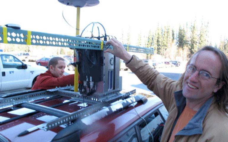  Geophysical Institute graduate student Austin Johnson, left, and glacier researcher Chris Larsen install a GPS laser system on top of Larsen’s Subaru Legacy on the UAF campus. Photo by Ned Rozell