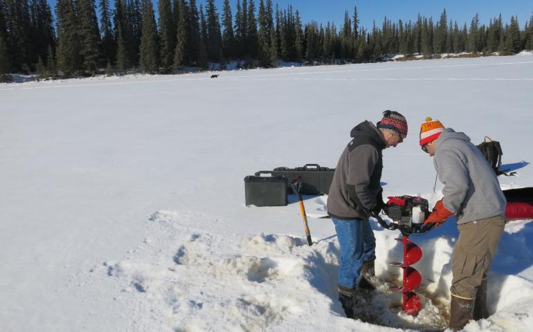 Chris Arp and Ben Gaglioti maneuvering an auger on the pond ice. 