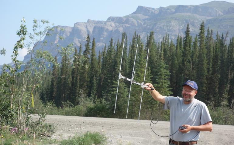 UAF professor Knut Kielland listens for radio-collared snowshoe hares north of Coldfoot on the Dalton Highway in July 2017. Photo by Ned Rozell.