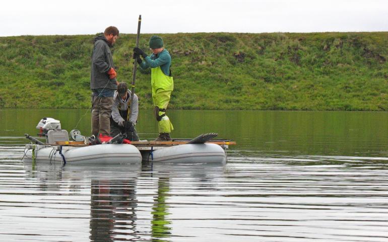 Researchers working with ecologist Nancy Bigelow pull a sediment core from a deep lake in western Alaska near Shishmaref, looking for pollen preserved from the days of the Bering Land Bridge. photo by Nancy Bigelow. 