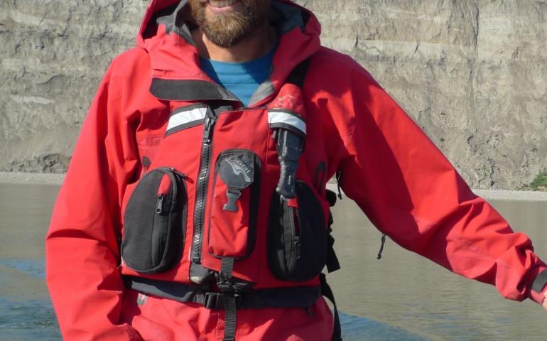 Pat Druckenmiller, dinosaur guy and director of the University of Alaska Museum of the North, ferries a boat across the Colville River near the spot rich with dinosaur bones. Photo by Greg Erickson.