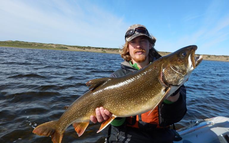 Kurt Heim shows a lake trout he caught in the Fish Creek watershed on the Arctic Coastal Plain. Photo by Lydia Smith.