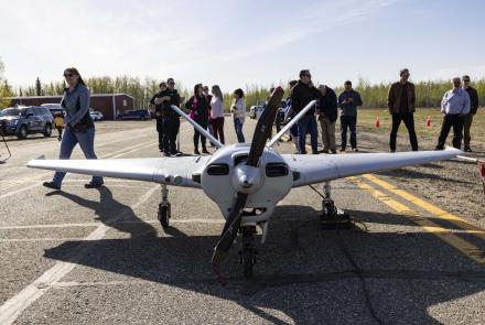 Event participants gather around the Sentry unmanned aircraft of the UAF Alaska Center for Unmanned Aircraft Systems Integration after a successful flight May 22, 2022, at Fairbanks International Airport. Photo by JR Ancheta/UAF Geophysical Institute