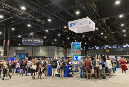 Visitors gather at the University of Alaska Fairbanks exhibitor booth at the AGU Fall Meeting 2022 in Chicago, IL. UAF GI Photo by Kelly Eagan.