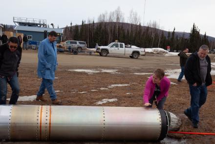 Astrophysicist Sabrina Savage of NASA’s Marshall Space Flight Center gives a "well done" pat to a recovered portion of a rocket launched April 17, 2024, from Poker Flat Research Range as part of NASA's new solar flare sounding rocket campaign. NASA photo