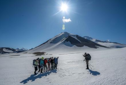 Research associate professor Pavel Izbekov photographs students on the return from a day hike with Novarupta in the background. Photo by Seth Adams