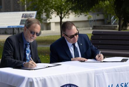 UAF Geophysical Institute Director Bob McCoy and Alaska Aerospace Corp. CEO John Oberst sign a memorandum of understanding in front of the GI building on Thursday, June 10, 2025. UAF/GI photo by Bryan Whitten: