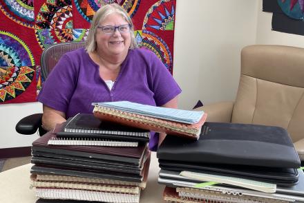 In June 2025, Kathe Rich sits in her office at Poker Flat Research Range behind notebooks she has filled with details of her 35 years at the rocket-launching facility. Photo by Ned Rozell.