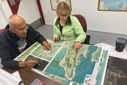 Two people look at a map in an office