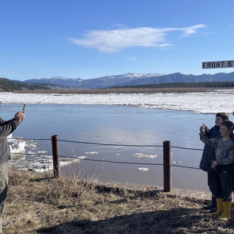 Ryan Becker, a teacher at the Eagle school, takes a photo of his students as part of a continuing Yukon River ice study on May 12, 2023. Photo by Ned Rozell.