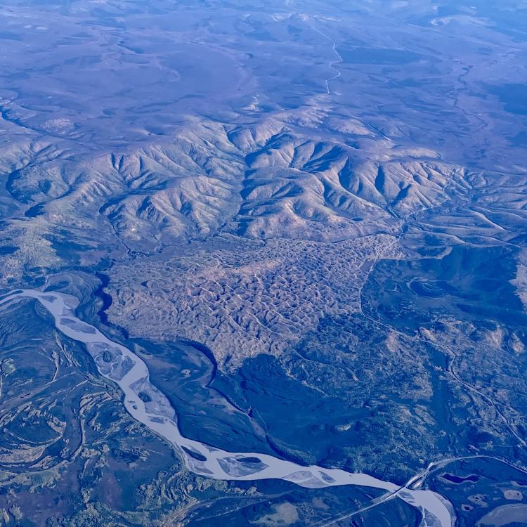 A vegetated sand dune that formed between the Tanana River, Interior Alaska hills and the Taylor Highway, as seen from a flight from Seattle to Fairbanks. The Alaska Highway Bridge over the Tanana River is visible at bottom. Photo by Ned Rozell.